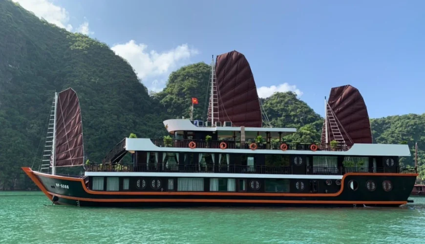 Cozy Boutique Cruise sailing through the limestone karst landscape of Lan Ha Bay, Vietnam.