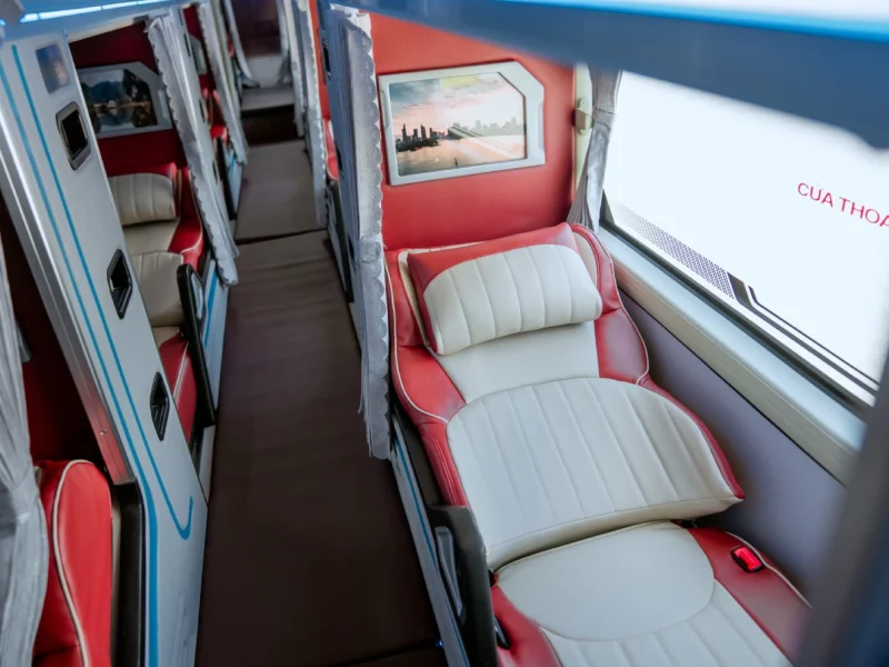 Spacious interior of the VIP cabin Bus from Hanoi to Ha Giang featuring private flat beds and LCD screens.